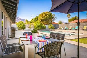 a patio with a table and chairs and an umbrella at Palm Springs Life in Palm Springs