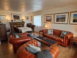 a living room with leather couches and a table at River Run Ranch - Telemark in Drangedal