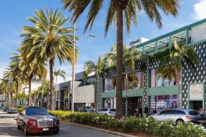 una strada con palme di fronte a un edificio di Luxury Beverly Hills Apartment a Los Angeles