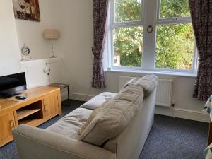 a living room with a couch and a television at The Snug on Hornby in Morecambe