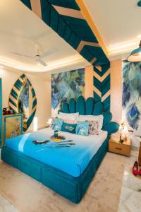 a bedroom with a blue bed with a striped wall at Hotel Sarang Palace - Boutique Stays in Jaipur