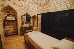 - une chambre avec 2 lits et un miroir dans l'établissement Hanedan Konağı Butik Otel Deluxe Triple Room with Turkish Bath Marvina, à Mardin