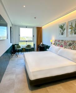 1 dormitorio con 1 cama blanca grande en una habitación en Ribera de Triana Hotel, en Sevilla