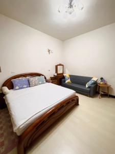 a bedroom with a large bed and a couch at Jiajia Inn in Lukang