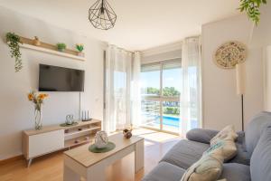 a living room with a blue couch and a tv at Casa Gemma in Alcanar