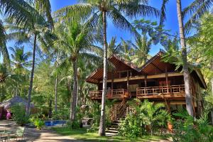 a bamboo house in the middle of palm trees at Villas SAMALAMA Gili Trawangan in Gili Trawangan