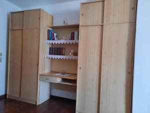 una camera con due armadi in legno e una libreria di Appartamento HAPPY DAYS (CIPAT: 022139-AT-837180) a Pergine Valsugana