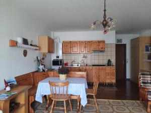 una cucina con tavolo e alcune sedie e tavolo e una cucina di Appartamento HAPPY DAYS (CIPAT: 022139-AT-837180) a Pergine Valsugana