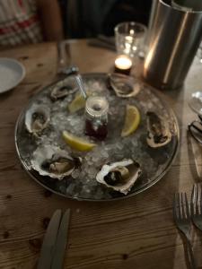 a plate of oysters on a table with lemon slices at The Snug- With Private parking in Whitstable