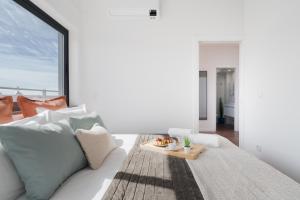 Cette chambre blanche dispose d'un canapé et d'une table. dans l'établissement Sunny Bright Flat w Balcony - Ace Location, à Porto
