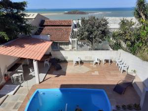 a view of a patio with a swimming pool and the ocean at Casa na praia de Setiba com panorama fantástico in Guarapari