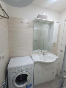 a bathroom with a washing machine and a sink at East Holiday Apartment 1 & 2 in Naples