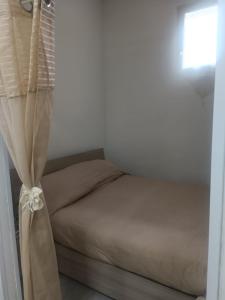 a bedroom with a bed with a window and a curtain at East Holiday Apartment 1 & 2 in Naples