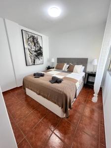 a bedroom with a large bed and a tile floor at Apartman Los Cristianos-Cristimar in Los Cristianos