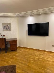 Luxury Apartment في بورسعيد: غرفة معيشة مع تلفزيون بشاشة مسطحة كبيرة على الحائط
