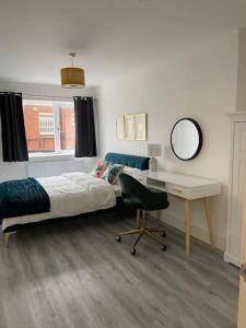 1 dormitorio con cama, escritorio y falda en Stunning and Spacious 2bed flat in central Woking en Woking