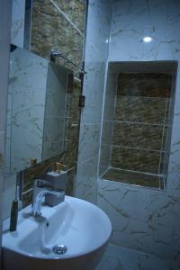 een badkamer met een witte wastafel en een spiegel bij Hasan Paşa Konuk Evi in Sanlıurfa
