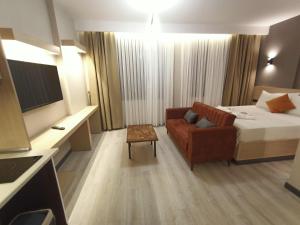 um quarto de hotel com uma cama, um sofá e uma televisão em NEW FALCON Palas OTEL em Istambul