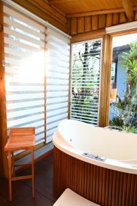 a bath tub in a room with a window at Casa das flores - Lavras Novas in Lavras Novas