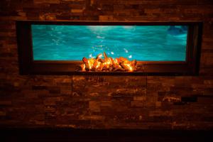 a fireplace with a television on top of it at Pension Lidana Resort & SPA in Vama