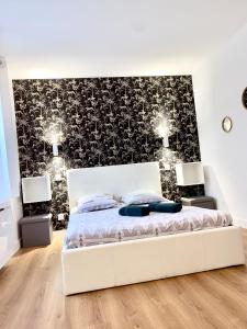 1 dormitorio con 1 cama con pared en blanco y negro en Superbe Appt avec cour et parking gratuit à 5min de la cité médiévale en Carcasona