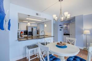 a kitchen and dining room with a white table and chairs at NTBSR3404 St Regis 3404 in North Topsail Beach