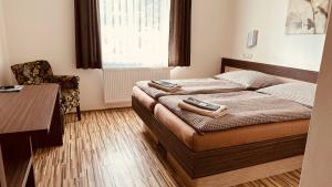 a small bedroom with a bed with two suitcases on it at Penzion Ranch in Hořovice