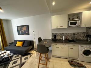 cocina y sala de estar con sofá y mesa en Le Saint Maixent, Maison de Ville, Baby Foot, wifi, en Saint-Maixent-lʼÉcole