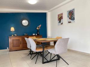 Maison Les Abymes - Plage à 50m في Le Prêcheur: غرفة طعام مع طاولة وكراسي خشبية