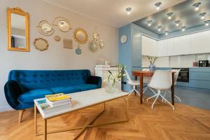 sala de estar con sofá azul y mesa en Project Comfort Apartament Aleje Jerozolimskie 131/12 Warszawa, en Varsovia