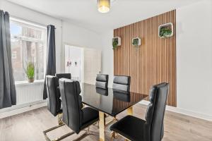 ein Esszimmer mit einem Tisch und schwarzen Stühlen in der Unterkunft Sophisticated 2 bed in Doncaster sleeps 6! in Balby