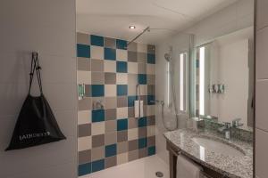 een badkamer met een wastafel en een spiegel bij Hampton by Hilton Düsseldorf City Centre in Düsseldorf