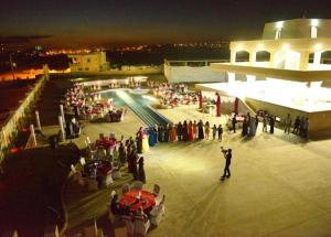a group of people standing around a pool at night at Akitu Hotel in Midyat