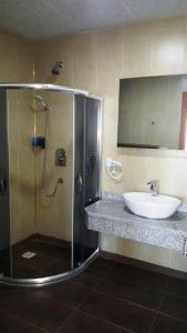 a bathroom with a shower and a sink at Akitu Hotel in Midyat