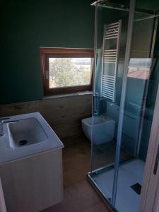ein Bad mit einem Waschbecken, einem WC und einem Fenster in der Unterkunft Appartamento dei Tigli in Bra