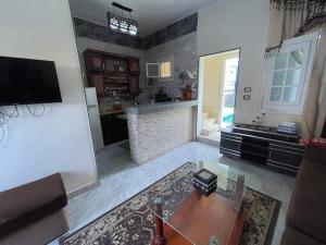 Bakar house في أسوان: غرفة معيشة مع طاولة ومطبخ