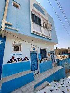 un edificio azul y blanco con una puerta azul en Bakar house, en Asuán