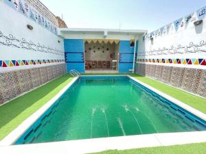 a swimming pool in a house with blue and white walls at Bakar house in Aswan