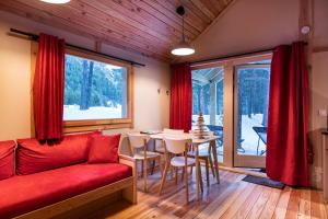 a living room with a red couch and a table at Huttopia La Clarée in Val-des-Prés