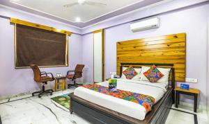 a bedroom with a large bed with a wooden headboard at FabHotel The Lodge in Jaipur