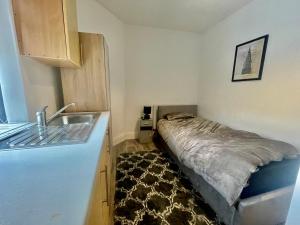 a small bedroom with a bed and a sink at Empire House in Burnley