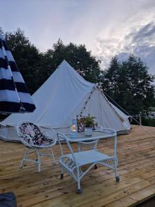 einen Tisch und Stühle auf einer Terrasse mit einem Zelt in der Unterkunft River Run Ranch - Telemark in Drangedal