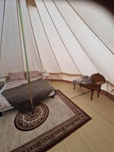 Cette chambre comprend une tente avec un lit et un tapis. dans l'établissement River Run Ranch - Telemark, à Drangedal