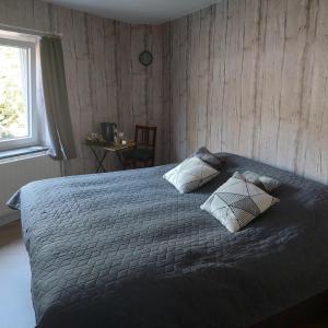 a bedroom with a bed with two pillows and a window at Au doux Chardon in Durbuy