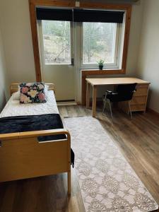 een slaapkamer met een bed, een bureau en een raam bij Easy Huoneistot Vierumäki in Härkälä