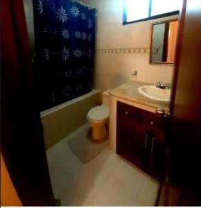 a bathroom with a sink toilet and a shower curtain at JOMALEY , Real HOTEL Jomaley in Loja