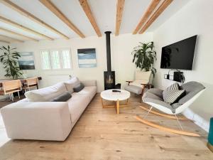 a living room with a white couch and a tv at Chalet in Lausanne newly renovated with river in Lausanne