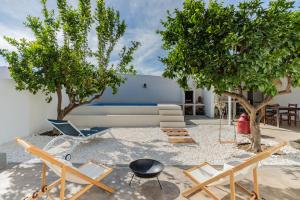 ein Wohnzimmer mit einem Sofa, Stühlen und Bäumen in der Unterkunft Casa da Avó Júlia Pestana (Piscina privada) in Torrão