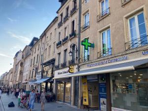 a group of people walking down a street with buildings at Confortable studio centre ville in Nancy