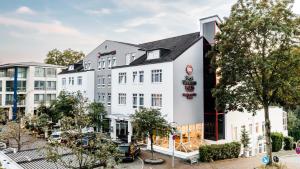 un grand bâtiment blanc avec un toit noir dans l'établissement Best Western Plus Hotel Stadtquartier Haan, à Haan